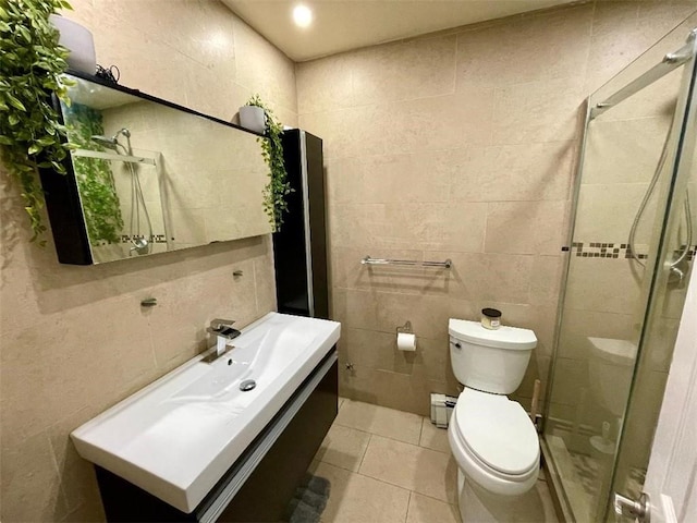 bathroom with vanity, tile patterned flooring, toilet, baseboard heating, and tile walls