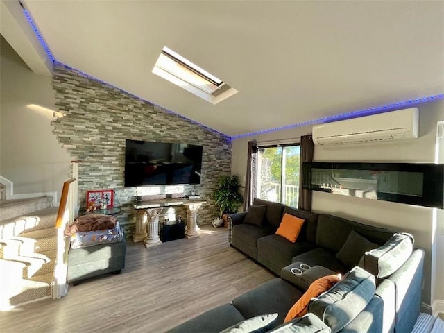 living room with vaulted ceiling with skylight, hardwood / wood-style floors, and a wall unit AC