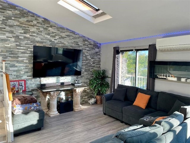 living room featuring wood-type flooring, an AC wall unit, and lofted ceiling with skylight