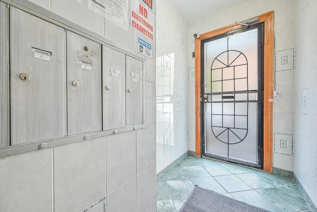 interior space with a mail area and light tile patterned floors