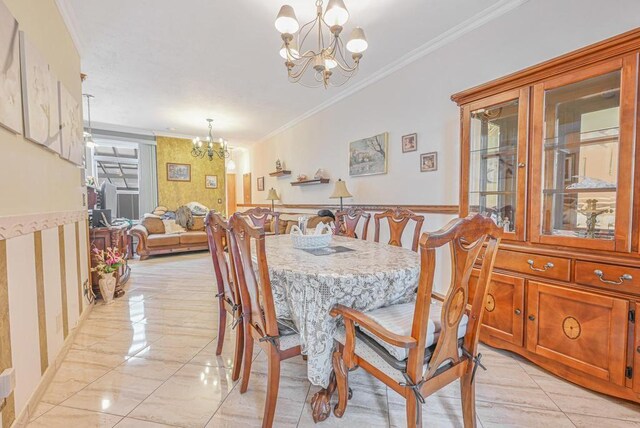 dining area with a chandelier and ornamental molding