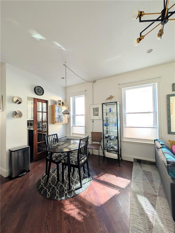 dining area with dark wood-type flooring and a chandelier