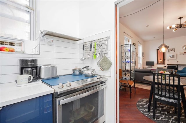 kitchen with dark wood-type flooring, tasteful backsplash, blue cabinets, pendant lighting, and electric stove