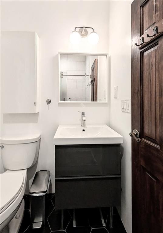 bathroom featuring a shower, vanity, and toilet