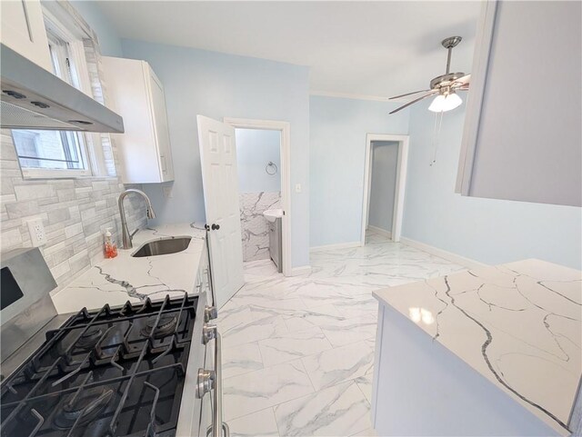 kitchen with white cabinetry, stainless steel gas stove, ventilation hood, and light stone countertops