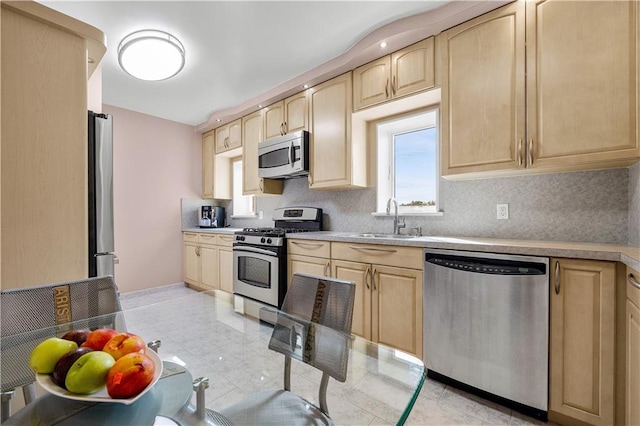 kitchen with light brown cabinetry, sink, and stainless steel appliances