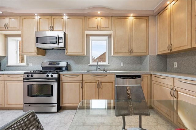 kitchen with light brown cabinetry, stainless steel appliances, sink, and tasteful backsplash