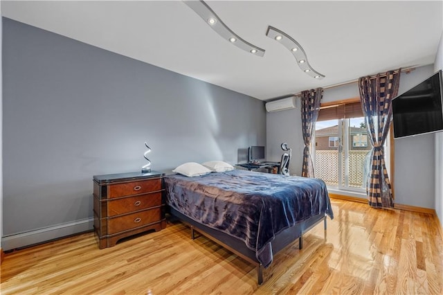 bedroom featuring a wall unit AC and light wood-type flooring