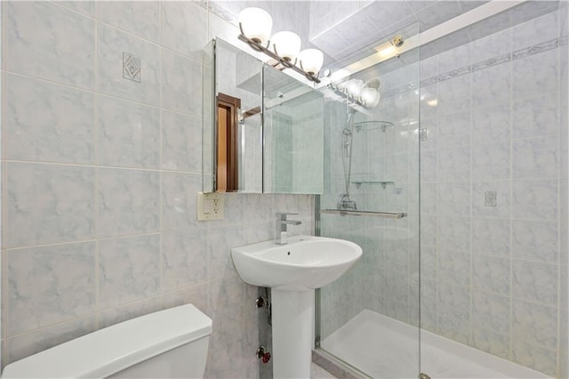 bathroom with a shower with door, toilet, and tile walls