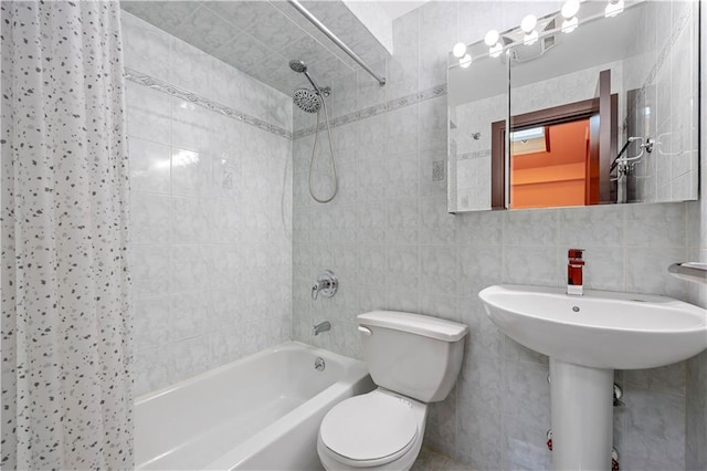 bathroom with toilet, shower / tub combo, and tile walls