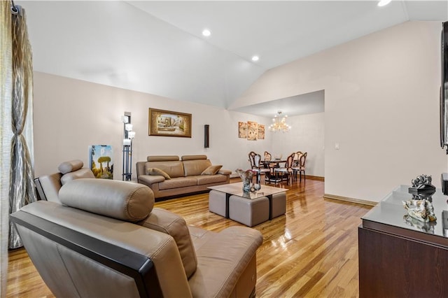 living room featuring an inviting chandelier, lofted ceiling, and light hardwood / wood-style floors