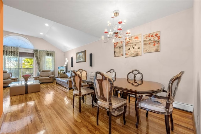 dining room featuring a chandelier, vaulted ceiling, and light hardwood / wood-style flooring