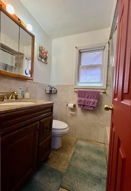 bathroom with vanity, tile patterned flooring, toilet, a shower with shower curtain, and tile walls