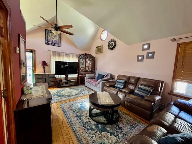 living room with high vaulted ceiling, wood finished floors, and ceiling fan