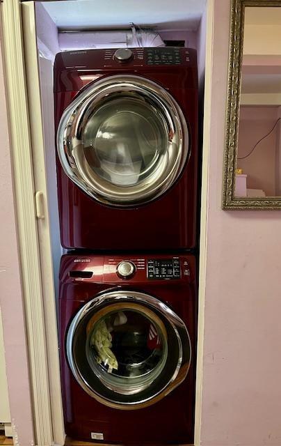laundry area featuring stacked washer / drying machine and laundry area