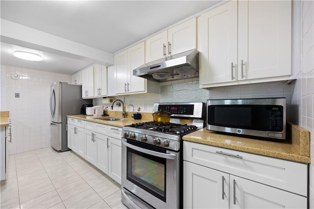 kitchen with white cabinetry, sink, stainless steel appliances, and light stone counters