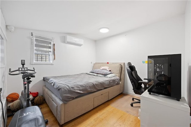 bedroom with light hardwood / wood-style floors and a wall mounted AC