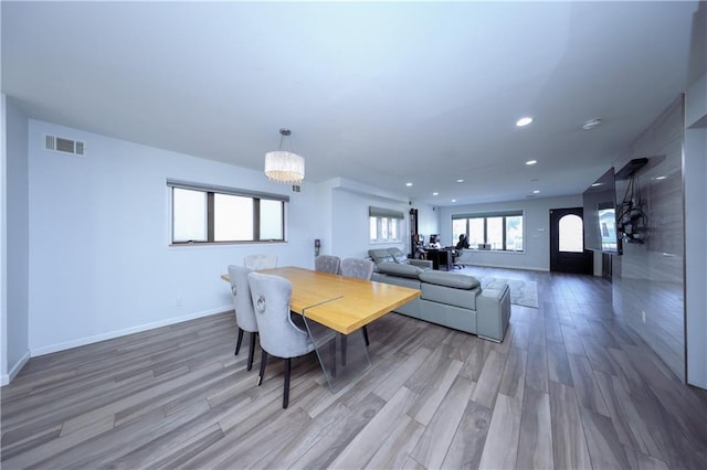 dining room with hardwood / wood-style floors and a notable chandelier