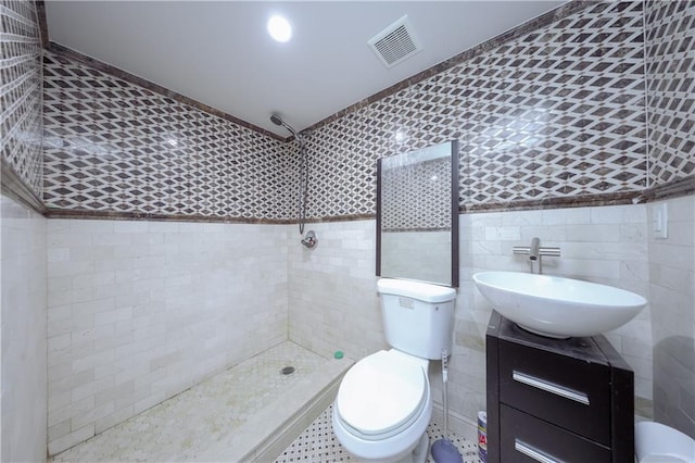 bathroom featuring toilet, vanity, tile walls, and tiled shower