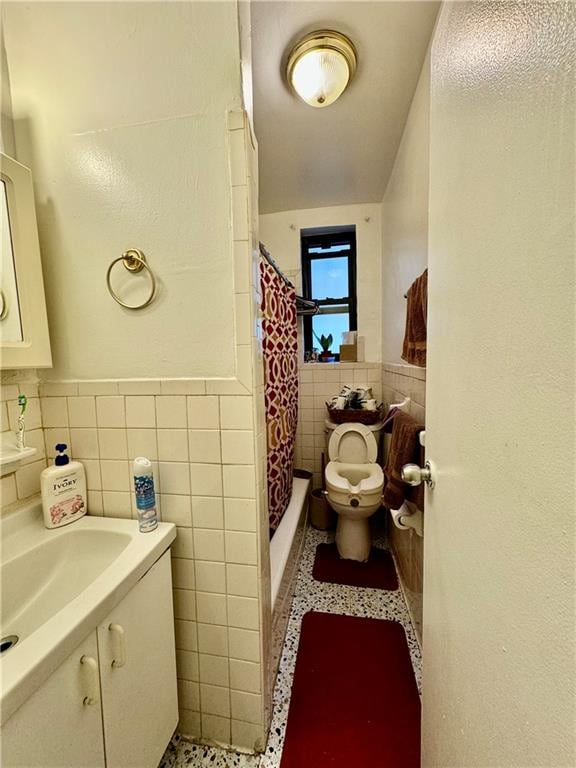 bathroom featuring toilet, tile walls, tile patterned floors, walk in shower, and vanity