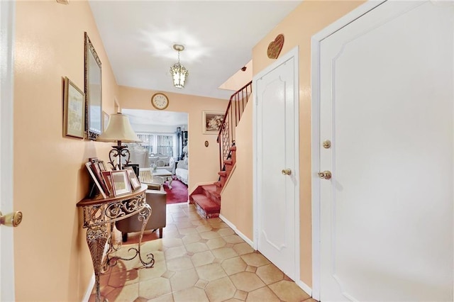 corridor featuring an inviting chandelier and light tile patterned floors