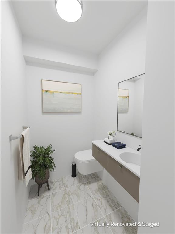 bathroom with vanity, toilet, and marble finish floor