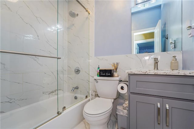 full bathroom with toilet, vanity, and shower / bath combination with glass door