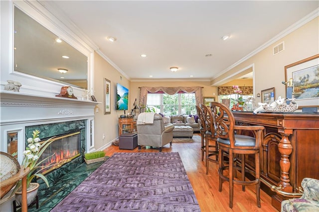 living room featuring recessed lighting, visible vents, wood finished floors, and a high end fireplace