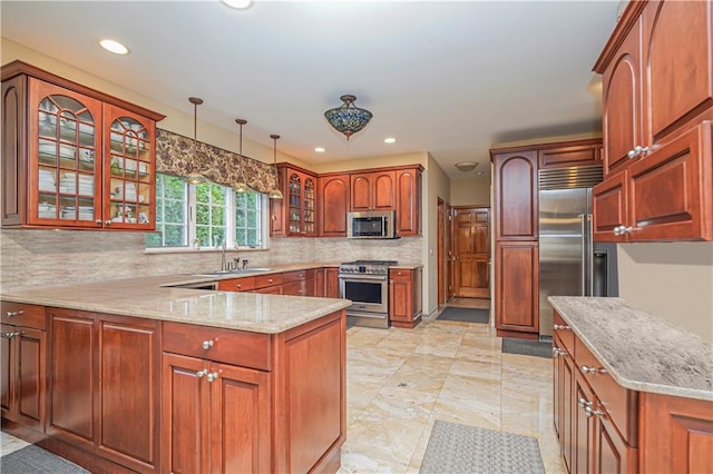 kitchen with decorative backsplash, high end appliances, a sink, a peninsula, and glass insert cabinets