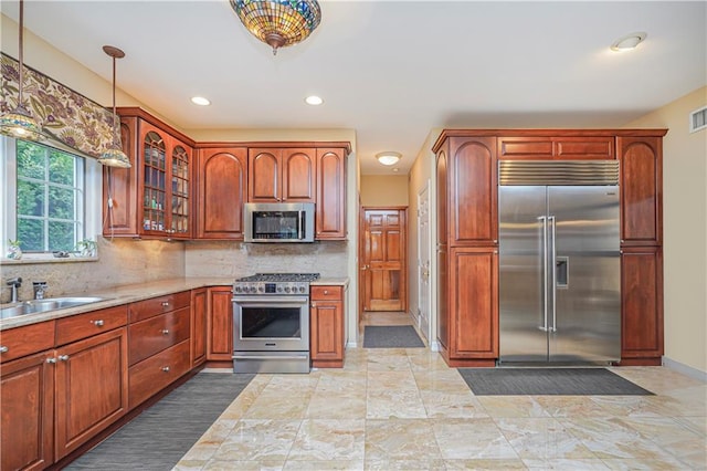 kitchen featuring backsplash, visible vents, a sink, glass insert cabinets, and stainless steel appliances