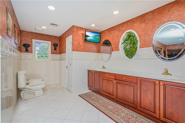 full bath with a sink, toilet, double vanity, and visible vents