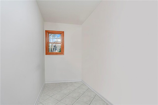 unfurnished room featuring baseboards and light tile patterned floors