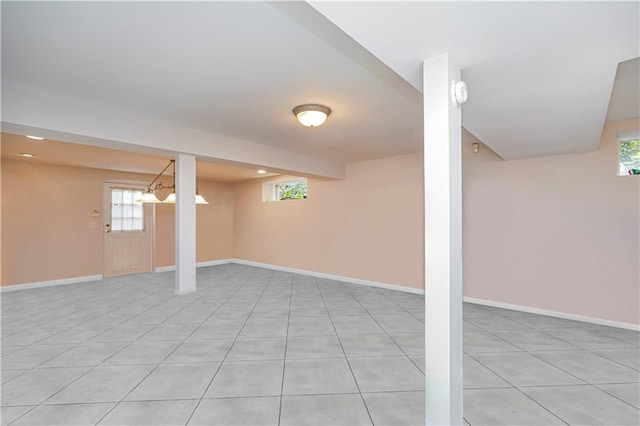 basement with a healthy amount of sunlight, baseboards, and light tile patterned floors