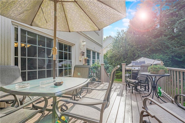 wooden deck with outdoor dining space and area for grilling