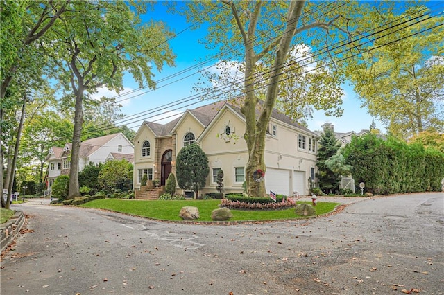 15 The Oval, Staten Island, NY 10304 - traditional-style house with a garage, stucco siding, a front yard, and aphalt driveway