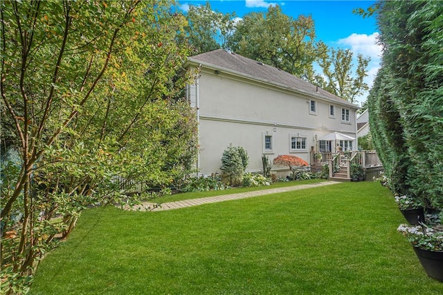 exterior space with a lawn, stucco siding, and a deck