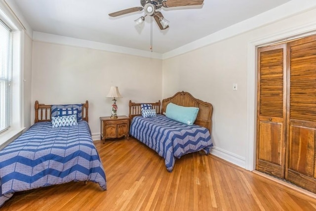 bedroom featuring ceiling fan, wood-type flooring, and a closet