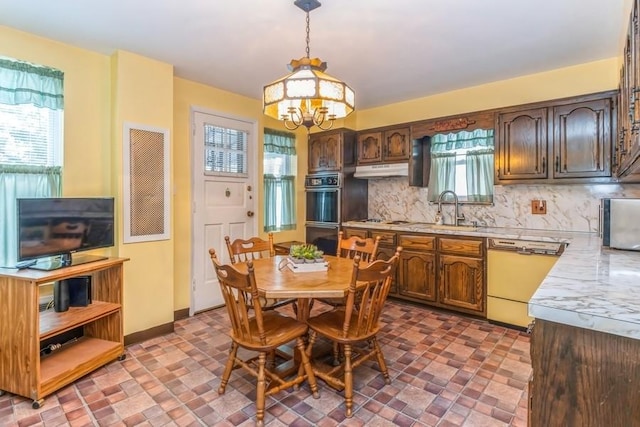 dining room featuring sink and a chandelier