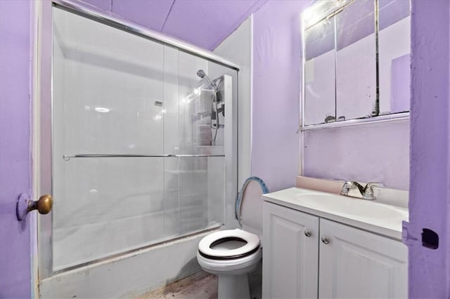 full bathroom with bath / shower combo with glass door, wood-type flooring, vanity, and toilet