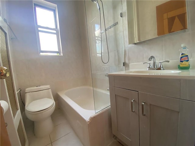 full bathroom with vanity, toilet, tile patterned floors, and tile walls