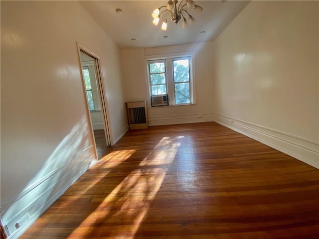 unfurnished room featuring cooling unit, a chandelier, and dark hardwood / wood-style floors