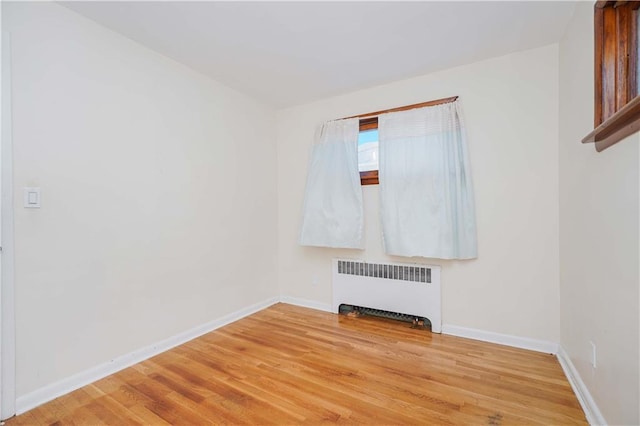 spare room with hardwood / wood-style flooring and radiator