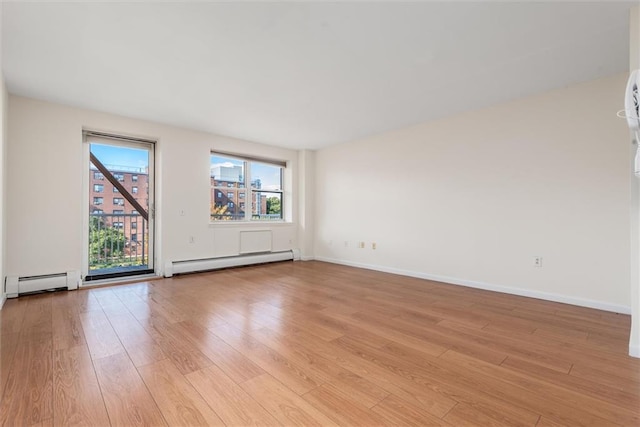 empty room with a baseboard heating unit and light wood-type flooring