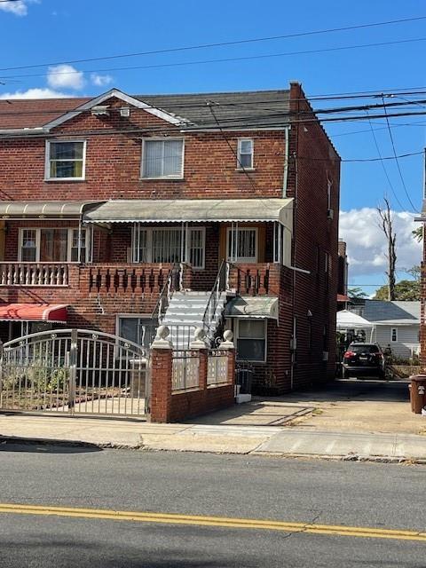 multi unit property with brick siding and a fenced front yard