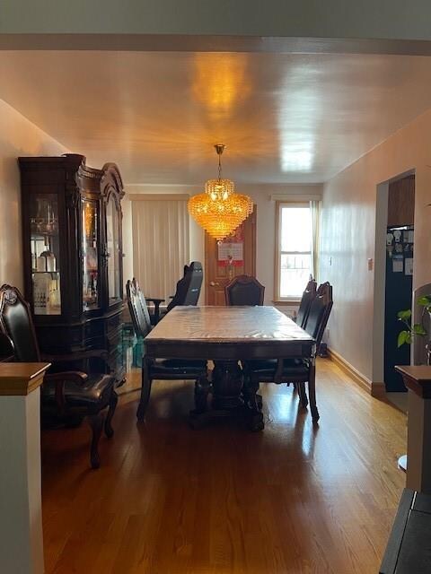 dining area with hardwood / wood-style flooring and a notable chandelier