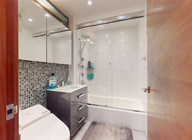 full bathroom with bath / shower combo with glass door, tasteful backsplash, tile walls, recessed lighting, and vanity