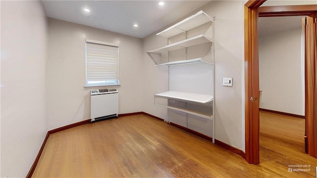 interior space featuring radiator, baseboards, wood finished floors, and recessed lighting