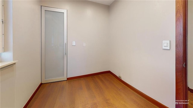 spare room featuring baseboards and wood finished floors