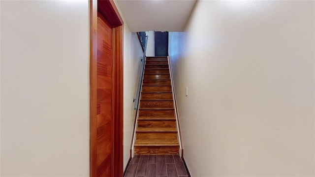 stairs featuring wood finished floors and baseboards