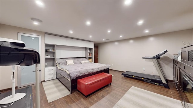 bedroom featuring baseboards, wood finished floors, and recessed lighting